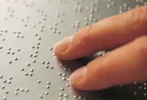 testo in braille e dita che leggono